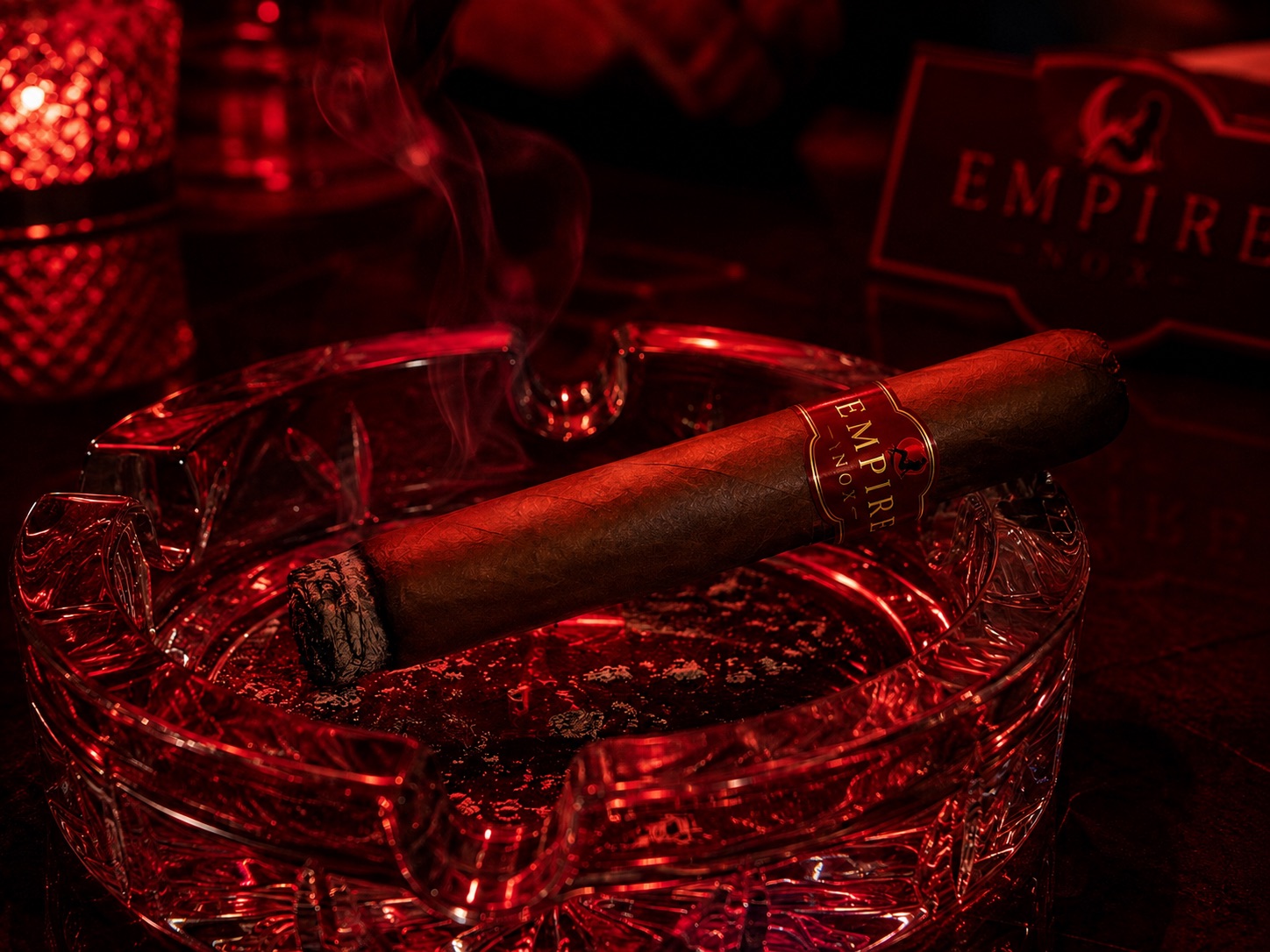 Empire Nox cigar in a crystal ashtray under red light